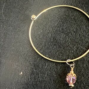 Gold tone bracelet with pink crystal charm